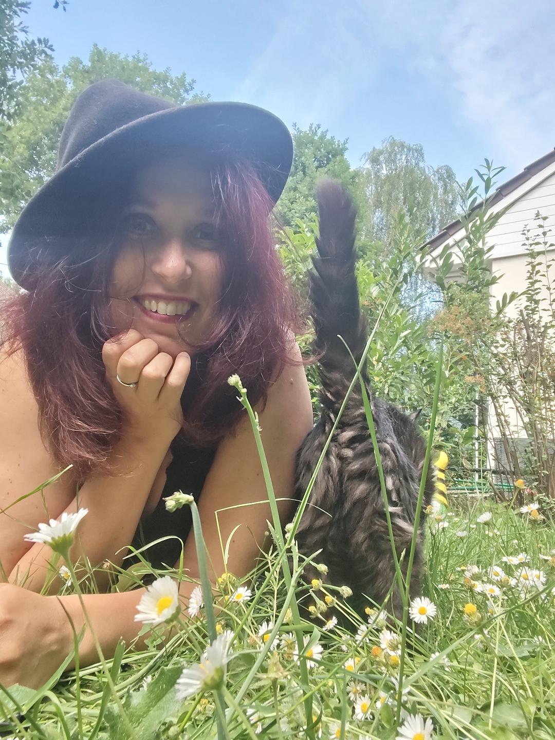 Delphine Oulès, comportementaliste chat et chien, en extérieur avec son chat dans l'herbe